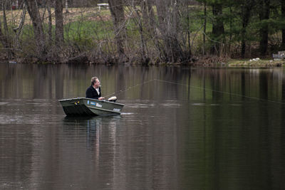 Man sitting in boat on lake