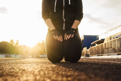 Low section of woman standing on road in city