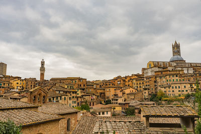 Buildings in city against cloudy sky