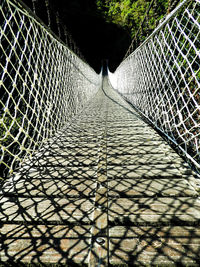 View of footbridge through chainlink fence