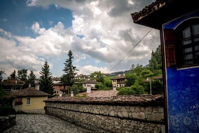 Houses and buildings in town against sky