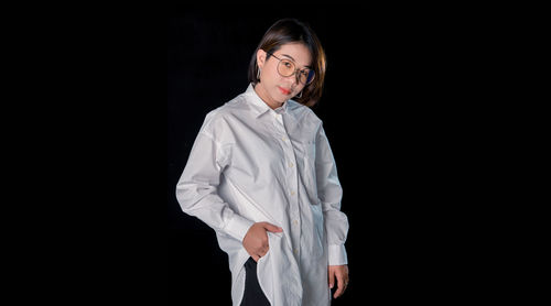 Young woman standing against black background
