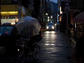 Cars on illuminated street in city at night
