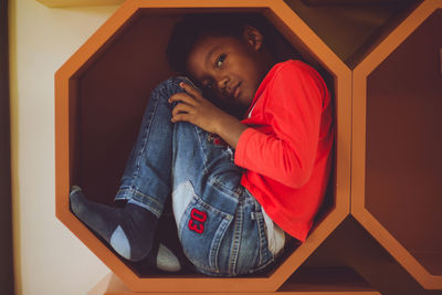 Rear view of girl sitting at home