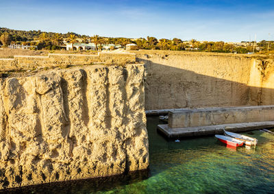 View of boats in canal against wall