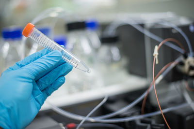 Cropped hand of scientist holding medical sample in container at laboratory