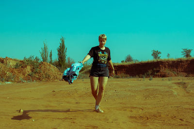 Full length portrait of beautiful young woman on land