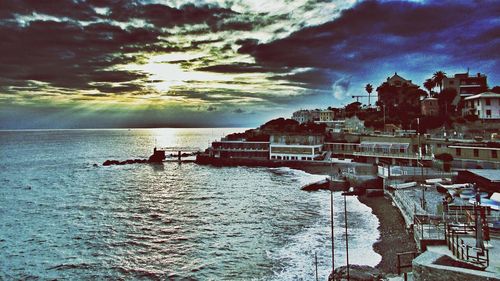 Boats in river against cloudy sky