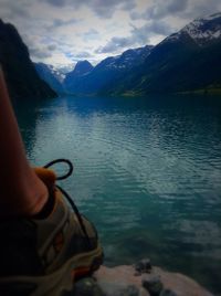 Midsection of man holding lake against mountains