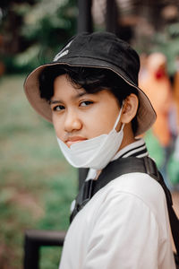 Portrait of teenager girl wearing mask and hat outdoors