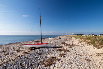 Sailboat on beach against sky