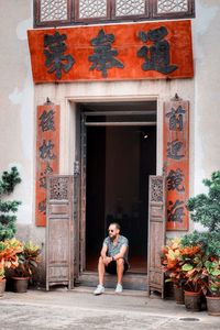 Full length of man sitting at entrance