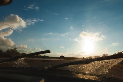 Cars on road against cloudy sky