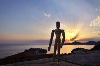 Silhouette man on beach against sky during sunset