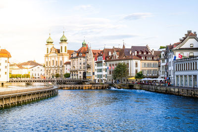 River amidst buildings in city against sky