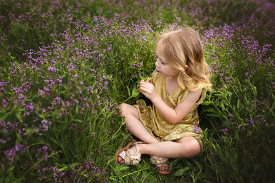 Portrait of young woman sitting on grassy field