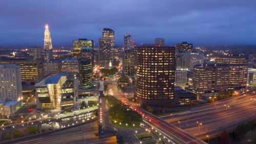 Aerial view of illuminated buildings against sky at night