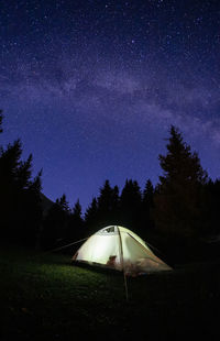 Tent on field against sky at night