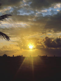 Scenic view of silhouette field against sky during sunset