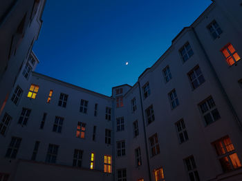 Low angle view of illuminated buildings against sky at dusk