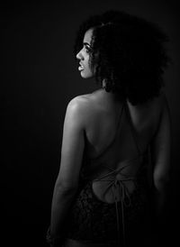 Young woman standing against black background