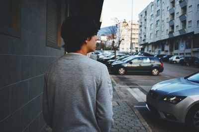 Rear view of man standing on street in city