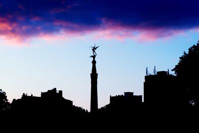 Low angle view of silhouette buildings against sky at sunset