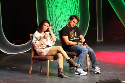 Full length of young couple sitting on seat