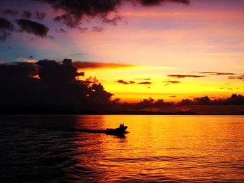 Silhouette of boat in sea during sunset