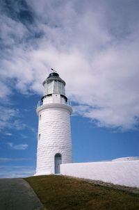 Lighthouse by sea against sky