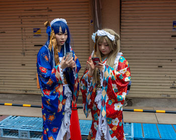 Full length of a smiling young woman holding umbrella