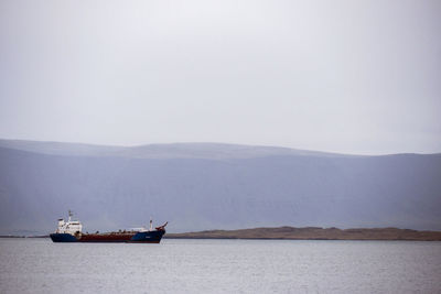 Ship sailing on sea against sky