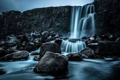 Low angle view of waterfall against sky