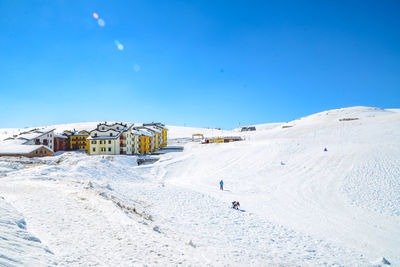 Scenic view of snowcapped mountains against blue sky