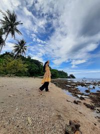 Full length of woman on beach against sky