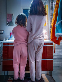 Rear view of two young girl brushing their thoots before going to sleep