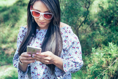 Young woman using mobile phone in park