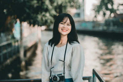 Portrait of smiling young woman standing outdoors