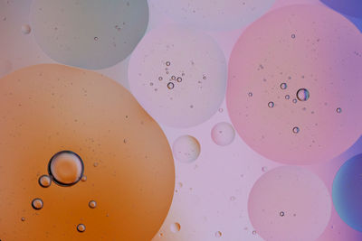 Top view oil bubbles drop on the water with colorful background, macro photography concept