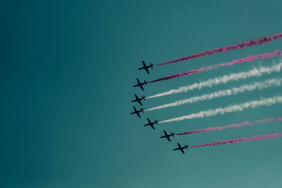 Low angle view of airshow against sky