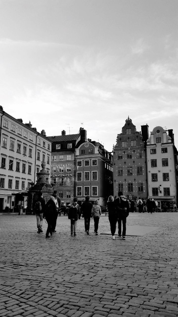 building exterior, architecture, built structure, city, sky, men, street, walking, person, city life, cobblestone, large group of people, lifestyles, town square, building, old town, residential building, residential structure, leisure activity