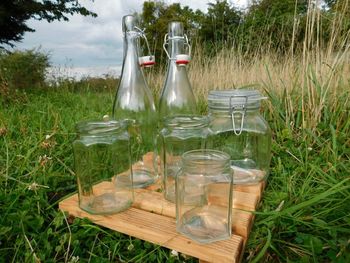 Drinking water in glass bottle on field