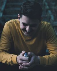 Man holding cigarette lighter while sitting on steps