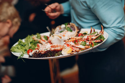 Midsection of person holding food in plate