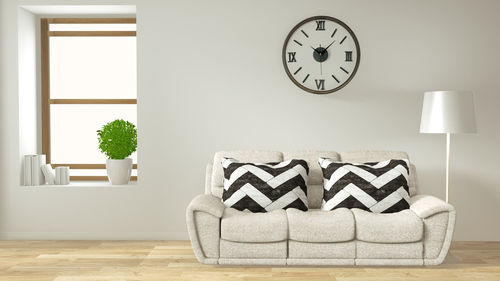 Close-up of clock on table against wall at home