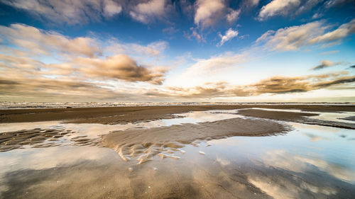 Scenic view of beach against sky during sunset