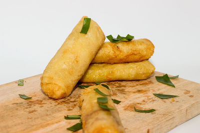 Close-up of bread on cutting board against white background