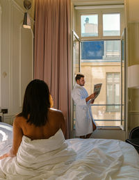 Morning wake up in bed in paris with breakfast coffee and a newspaper,men and woman honymoon