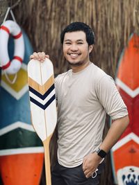 Portrait of smiling young man with arms raised
