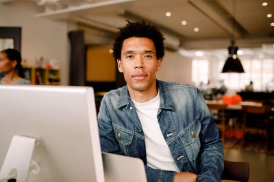 Portrait of confident young businessman sitting in office